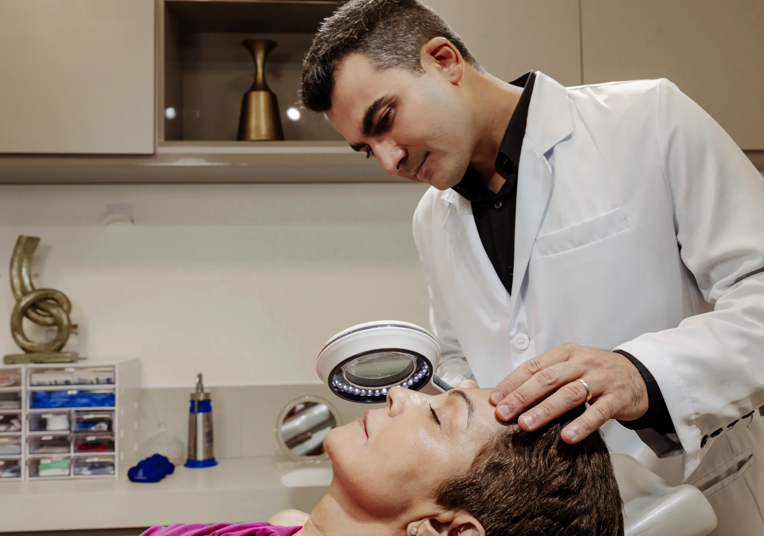 Dr. Edmundo Rocha avaliando a pele do rosto de uma paciente